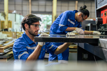 Attractive two male industrial worker working in manufacturing plant. 