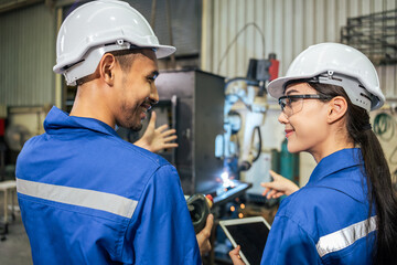 Asian male and female industrial worker working in manufacturing plant