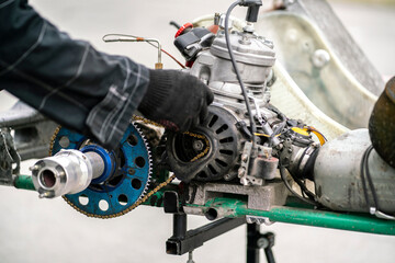 Fototapeta premium mechanic repair the karting engine in workshop