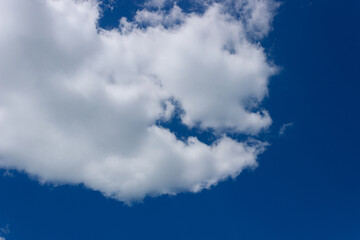 White clouds in a blue sky on a sunny summer day. Background, blank