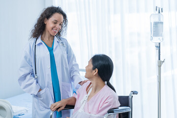 Obraz premium Asian young woman doctor support patient female sitting on wheelchair. 