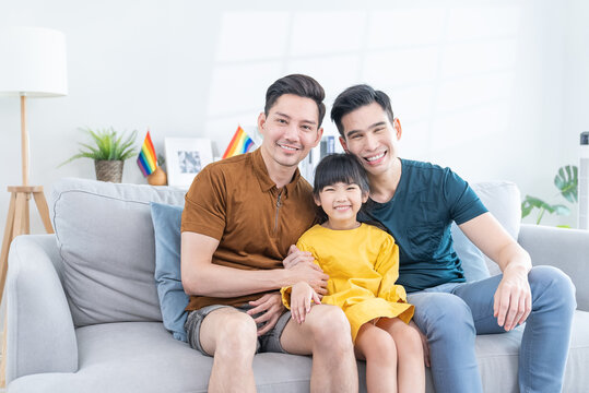 Portrait Of Asian LGBTQ Gay Loving Family Sit On Sofa With Girl Kid. 