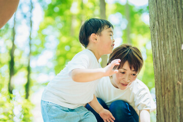 森の中を探検する男の子と親