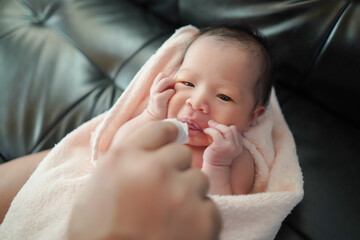 Parent helps to brush the teeth of a newborn baby, Hygiene of the baby’s mouth