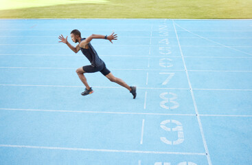 Athlete running on track during competitive training practice. Full length athletic, fit, active...