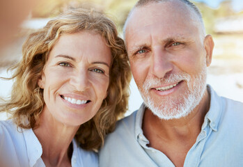 Portrait of happy mature caucasian couple taking a selfie while bonding together on holiday...