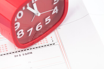 The alarm clock shows the exam time on the answer sheet