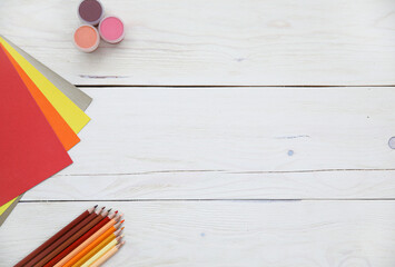 coloured pencils, coloured paper and wood surface drawing accessories, layouts