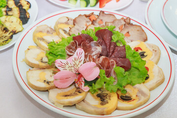 a full plate of cut different pieces of meat in a restaurant
