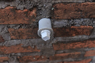 Water connection without faucet planted in brick wall	