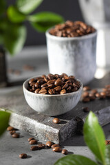 A handful of roasted coffee beans in Minsk on a grey background.