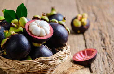 Fresh Mangosteen in bamboo basket and on old wood baclground. Queen of Fruits, asia fruits concept