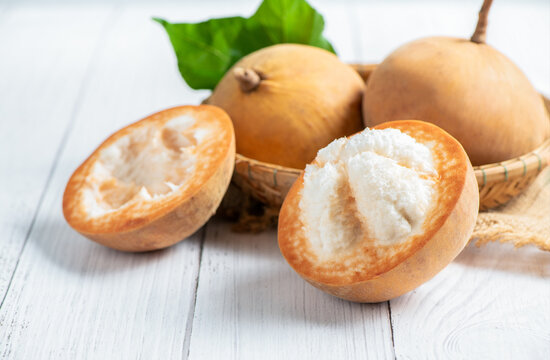 Half Santol on wood background, Santol has sour taste and the middle of santol is sweeter.