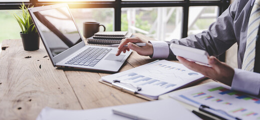 Portrait of a businessman working on a tablet computer in a modern office. Make an account analysis...