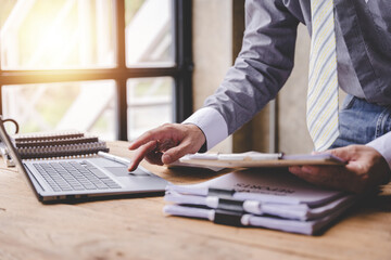 work from office A businessman works a bunch of paper files to find information on his desk at home. business report pile of unfinished documents