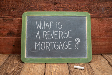 What is a reverse mortgage? A question written in white chalk on a slate blackboard, finance and...