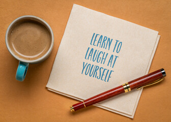 learn to laugh at yourself inspirational note on a napkin with coffee, personal development concept