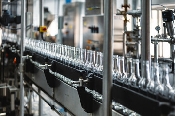 Production line transports empty glass bottles for alcohol