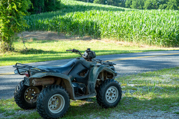 Green off-road vehicle in foreground with agricultural cornfield © Mary Salen