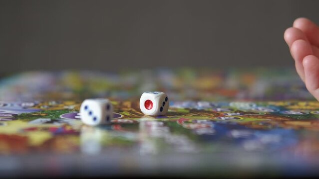Wooden dice for children. A child hold a wooden dice in her hands in the room.