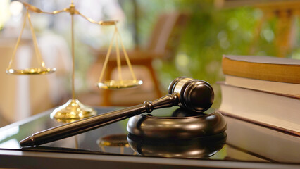Lawyer or judge's hammer in the court. Auction's hammer is on woo table. Law subject or auction firm with book and golden judge's scale as symbol.