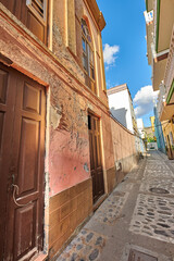 Fototapeta na wymiar Scenic view of old historic houses, residential buildings, traditional infrastructure in small alleyway, street, road. Tourism, travel destination abroad and overseas in Santa Cruz de La Palma, Spain