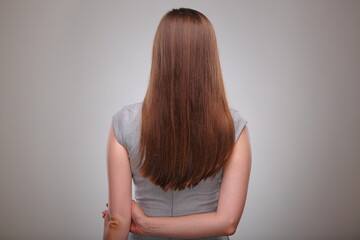 Obraz premium Isolated business woman back view portrait with hands crossed behind, business person, teacher or adult student with long hair.