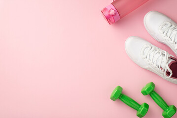 Fitness concept. Top view photo of white sports shoes pink bottle of water and green dumbbells on isolated pastel pink background with empty space