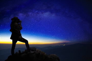 Photographer doing astro photography in a mountain morning scape with milky way galaxy. The...