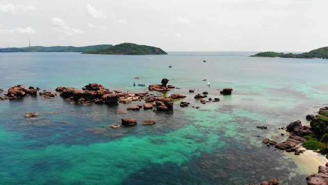 Aerial Orbit View of Rocky Coastline Landscape, Phu Quoc Vietnam, Rocks in Clear Turquoise Water next to the Coast Shore, Lands and islands in Background