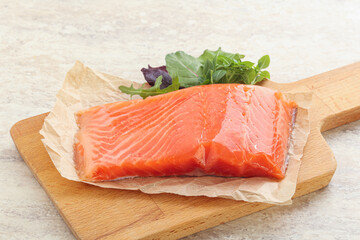 Raw salmon fillet over board