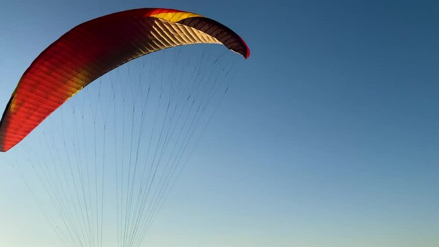 Paraglider takes off against the background of the blue evening sky