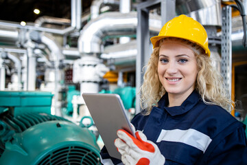 Portrait of female power plant worker holding tablet computer and controlling production.