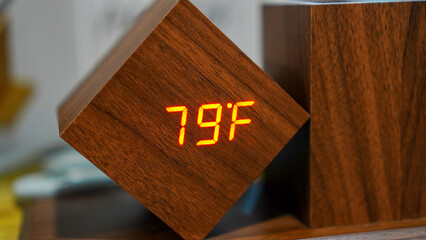 Digital room temperature gauge made of wood and red LED light indicating the temperature level is 79 fahrenheit