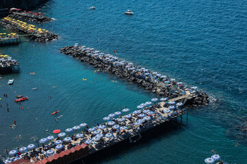 Top view - Beach for vacationers with sunbeds and umbrellas on the Tyrrhenian Sea in Sorrento.
