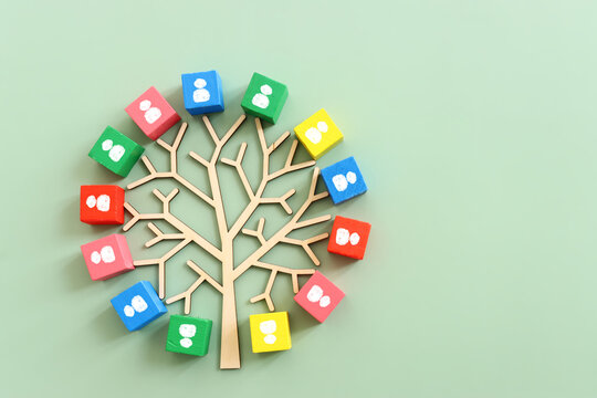 Business image of wooden tree with people icons over green background, human resources and management concept