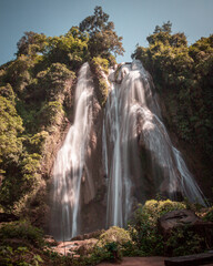 Obraz premium Anisakan waterfall near Pyin Oo Lwin in northern Myanmar ona bright sunny day with trees around.