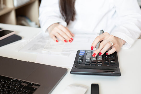Mortgage house credit accountant consulting woman calculating risks. Money female manager portrait photo with laptop, pen, making marks. View from behind