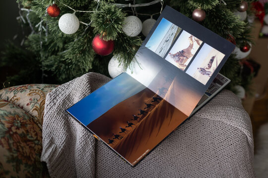 Photo book family photo album under the Christmas tree surrounded by Christmas gifts
