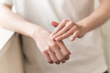 ハンドケアをする男性、手にクリームを塗る
