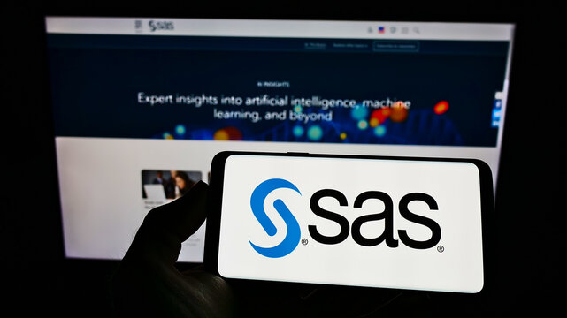 Stuttgart, Germany - 01-29-2022: Person holding cellphone with logo of US analytics software company SAS Institute Inc. on screen in front of webpage. Focus on phone display.
