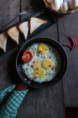 Scrambled eggs in a frying pan on a wooden background. Selective focus.