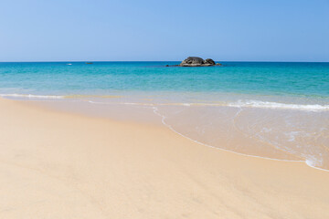 Fototapeta na wymiar Beautiful tropical island in south of Thailand, rock in blue sea with space on fine sandy beach