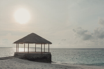 Sunrise in the ocean. Maldives, the deserted beach with water cafe.