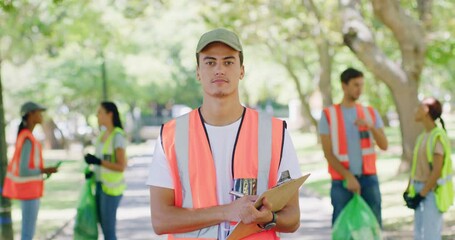 Portrait of a young environmental NGO employees at a park cleaning project. A group of volunteers wearing uniform working in a public garden. A team picking up litter together in a field
