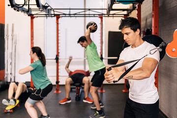 Group of beginners athletes exercising in a personal class with a private trainer. Various exercises