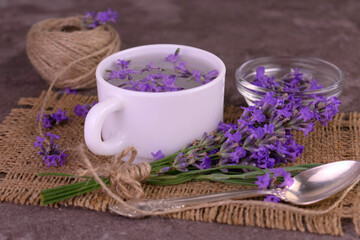 Fototapeta na wymiar Fragrant lavender tea in a cup bouquet of fresh lavender flowers.Close-up.