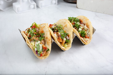 A view of a set of Indian fusion tandoori chicken tacos.