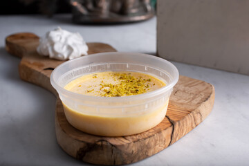 A view of a to-go plastic container of mango panna cotta or mango ice cream.