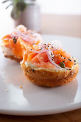 A view of a plate of lox on a bagel.